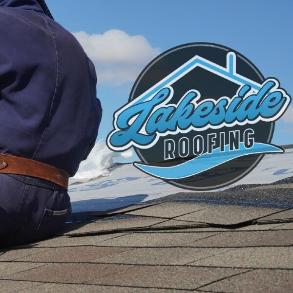 Man sitting on asphalt shingle roof with Lakeside Roofing Logo
