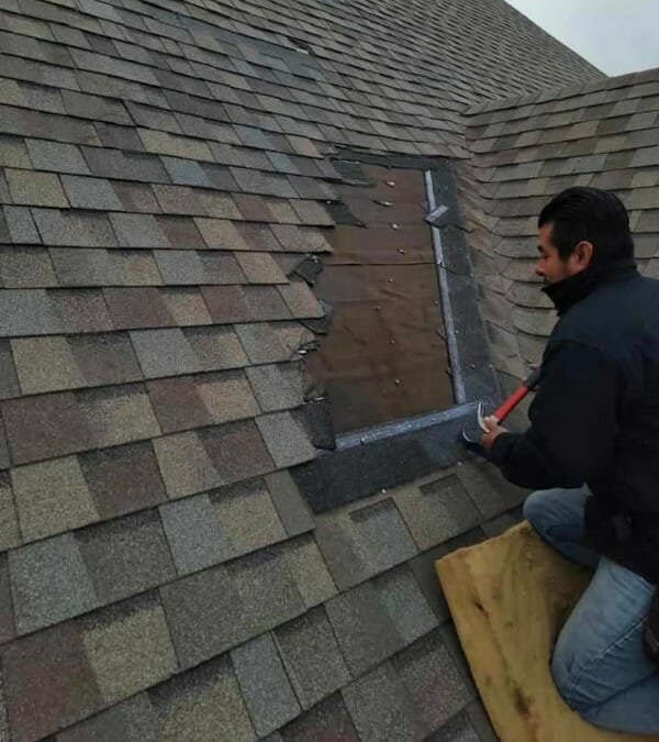 Man repairing an asphalt shingle roof